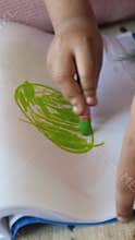 A Child Happily Enjoying a Vibrant Coloring Session with a Bright Green Crayon in Hand