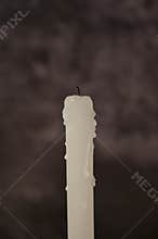 Close-up one white blown out candle on dark gray background