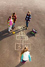 Kids play hopscotch