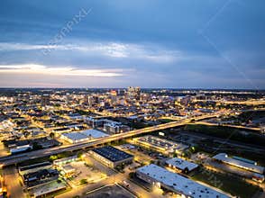 Aerial view of Birmingham, Alabama at dusk, showcasing the city's illuminated skyline and highway traffic, creating