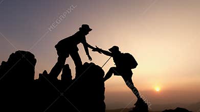 Silhouette of group team tourists lends helping hand climb cliffs mountains helping hand. teamwork helping hand business travel