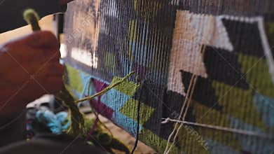 Man hands weaving carpet in Uzbekistan.