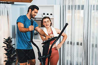 Athletic and sporty couple running on elliptical running machine at gaiety home.