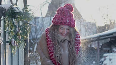 A young positive girl having fun in winter season, throwing snow up. Wintertime atmosphere in nature. Positive emotions