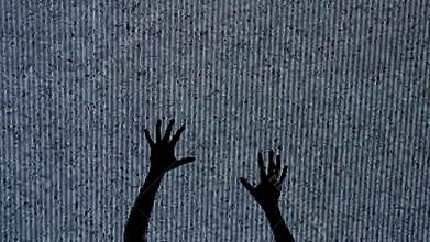 Silhouette against digital television screen. Thriller scene woman silhouette hands crawling up on big digital screen