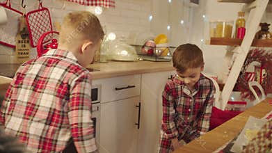 Cute boys dancing on the kitchen on Christmas Eve