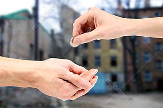 Hand gives coin to beggar