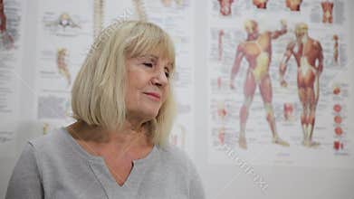 Woman with layered hair and bangs smiles in front of muscle poster at art event