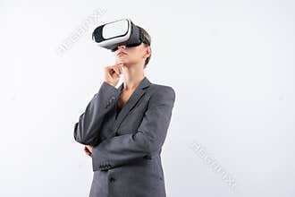 Smart businesswoman thinking about plan while wearing VR glasses. Contraption.