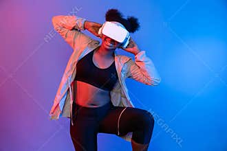 Young African sport woman wearing VR stretching whole body posing. Contrivance.