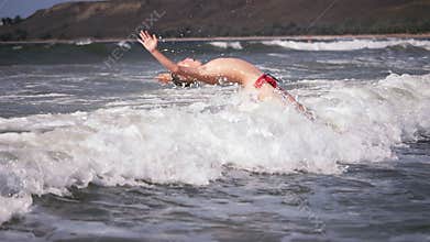 Two boys dive into a foaming wave. Live a healthy life. Be H3althy