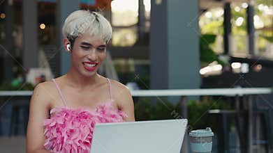 Young Attractive Transgender Man Outside Sitting on Table and Talking on Online Conference. LGBT Guy with Make-Up