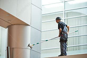 Woman worker cleaning indoor window