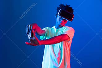 African sport player wearing VR stretching arm neon light wall. Contrivance.