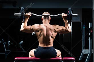 Man in gym or fitness studio on weight bench