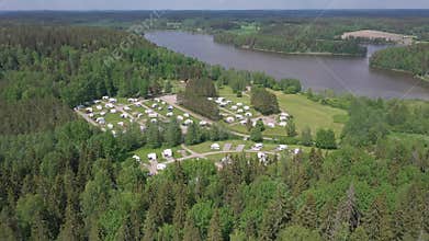 Pretty aerial shot of a caravan park next to a lake.