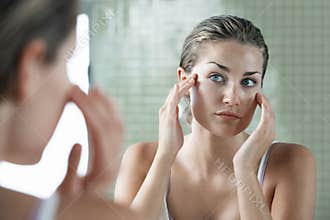 Woman Examining Herself In Front Of Mirror