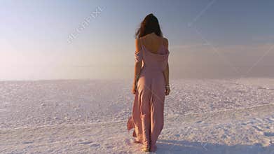 Woman Standing on Pink Salt Lake at Sunset in Flowing Dress