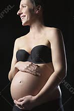 Smiling Pregnant Woman Touching Abdomen