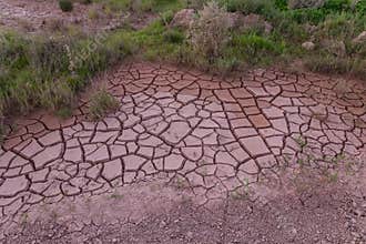 Cracked mud with interesting shapes in a dried up puddle next to the road.