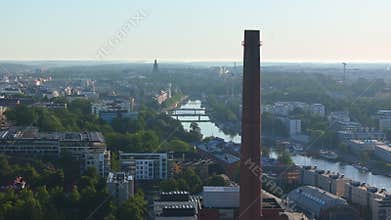 Camera panning over Turku, Finland showing the Aura River dividing the city and a prominent red brick industrial chimney