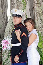 Bride with arms around military groom