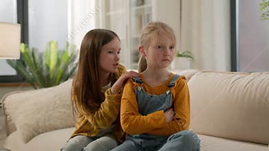 Two little Caucasian kids children siblings daughters girls argument remorseful sister apologizing hugging asking