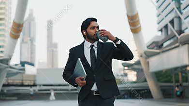 Indian businessman going by central street and singing along to music