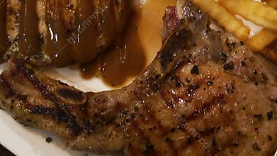 close up view to pork chop steak in a plate serving in Thai style restaurant
