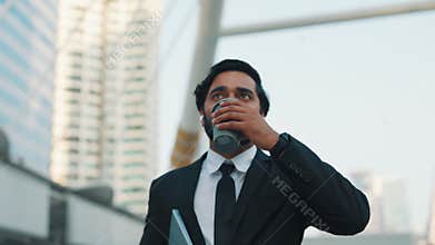 Inspired male walking by downtown and drinking coffee on go
