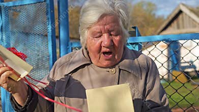 Grandmother opens gift, mouth opens in amazement and emotion Surprise unpack box