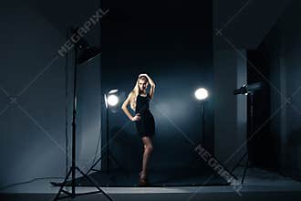 Beautiful woman posing at studio in light flashes