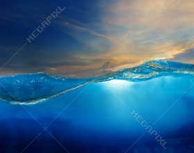 under clear water with beautiful dramatic sky above