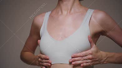A young woman checks and feels her breasts