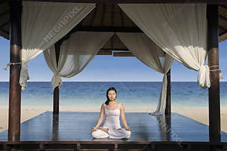 Asian woman practice yoga at luxury beach resort