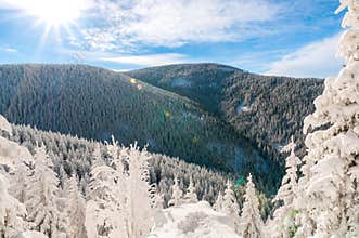 sun over the mountains on a winter day, mountain landscape, road to Kralicky Sneznik