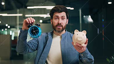 Finance adviser making speech with alarm clock and money box in hands