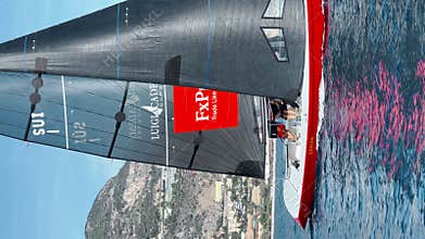 Monaco, Monte-Carlo, 25 October 2022: participant of sailing race in the sea, port Hercules in background, red boat with