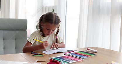 Girl with braids chooses bright felt-tip pen to draw picture