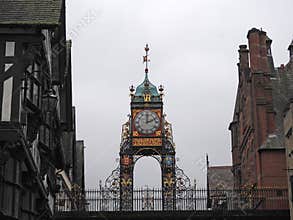 The Eastgate clock and clock in Chester city walls surrounded by the historic buildings on the road