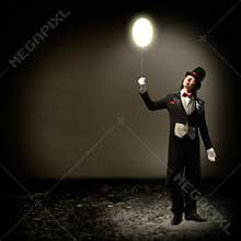 Magician holding a glowing balloon