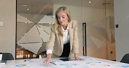 Financial analyst review papers with diagrams, pie charts, and graphs