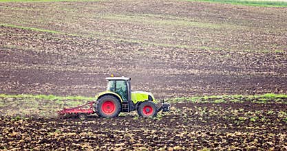Sustainable farming agriculture, tractor take care of crops in a farming field, cultivating fields