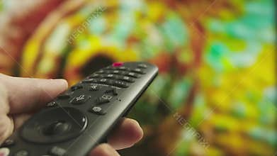 Woman with remote in hand switching channels, turning up the volume, smart tv technology internet video content, screen