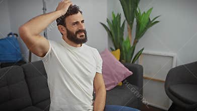 Pensive middle-aged man in white tee, doubting and in deep thought at home, consumed by uncertainty, confusion and wonder