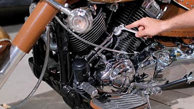 Person fixing motorcycle engine with automotive tools and parts