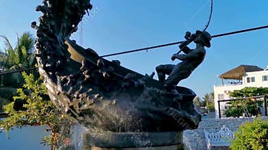 Statue sculpture angler with fish fountain in Puerto Escondido Mexico