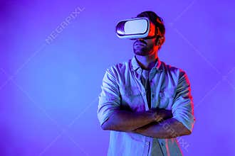 Smart caucasian man using virtual reality glass while crossing arm. Deviation.