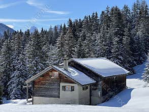 Old traditional swiss rural architecture and alpine livestock farms in the winter ambience of the tourist resorts in the Alps