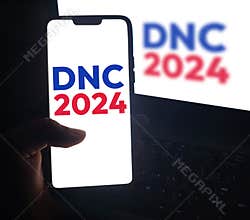 DNC 2024 news on mobile screen, presidential election concept backdrop